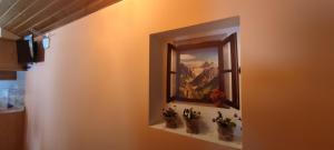 a wall with a mirror and some vases with flowers at Casa Cote in Torla