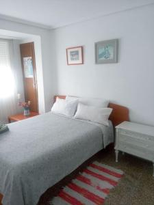 ein weißes Schlafzimmer mit einem Bett und einem Tisch in der Unterkunft Nice Spacious Flat in the Center in Valencia