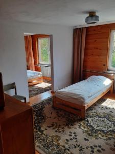 a bedroom with a bed sitting on a rug at Zwolaki in Ulanów