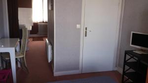 una puerta a una habitación con mesa y TV en Hotel Moderne, en Vire