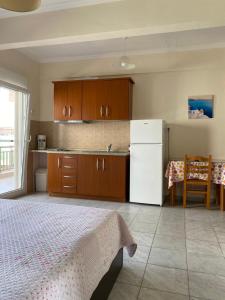 a kitchen with a bed and a white refrigerator at Villa Vasiliki in Metamorfosi