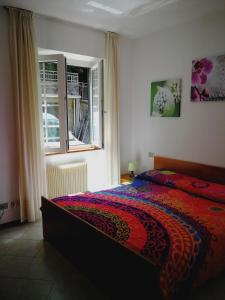 a bedroom with a bed with a colorful blanket at Belandin Ristorante Hotel in Teglio