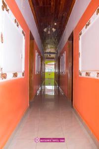 an empty corridor with orange walls and windows at Appart'hotel britannia in Yaoundé