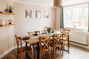 comedor con mesa de madera y sillas en Rodham House, Fenland Retreats at Willow Grange Farm, en Cambridge