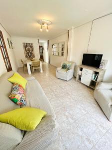 a living room with a couch and a television at Apartamento El Arenal - Free Parking in Córdoba