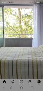 Una cama con una manta a rayas y una ventana en Destino Buenos Aires en Buenos Aires
