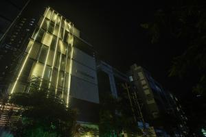 um edifício alto à noite com luzes acesas em Townhouse Hotel Eaglewood Gachibowli em Kondapur