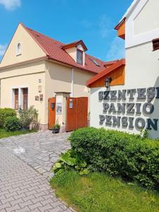 a building with a sign in front of it at Szentesi Panzió in Fertőrákos