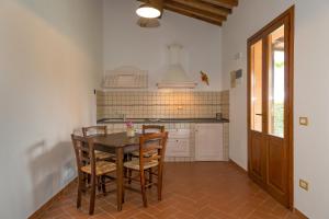 een keuken met een tafel en stoelen in een kamer bij Isolotto - Appartamento Quercia in Piombino