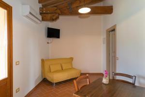 sala de estar con mesa y silla amarilla en Isolotto - Appartamento Quercia, en Piombino