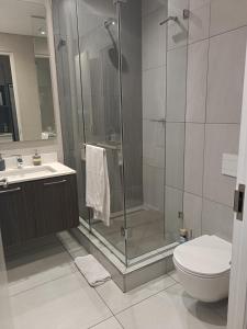 a bathroom with a shower and a toilet and a sink at Menlyn Maine Trilogy Apartment 101 in Pretoria