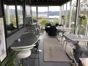 a restaurant with tables and chairs and windows at Art House in Huonville