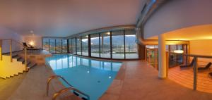 a large indoor swimming pool in a building with windows at Residence Aqualis in Marlengo