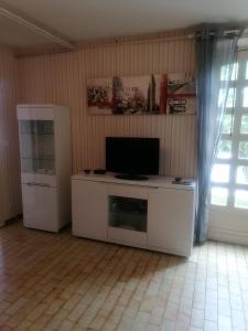 a living room with a television and a white cabinet at Gaillarde in Brive-la-Gaillarde