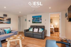 a living room with a couch and a table at Modern, Sea Themed Ground Floor Flat Near Beach in New Quay