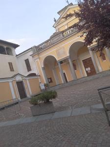 ein großes gelbes Gebäude mit einer Backsteinstraße in der Unterkunft La Nuvola in Sagliano Micca