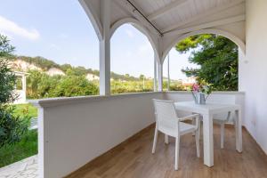 una veranda bianca con tavolo e sedie bianchi di Appartamento Iremar C4 - MyHo Casa a Vieste