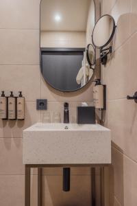 La salle de bains est pourvue d'un lavabo et d'un miroir. dans l'établissement Hotel St Joris I Kloeg Collection, à Middelbourg