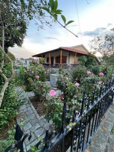 a house with pink flowers in front of a fence at Valsamo Luxury Cottage in Chaïdeftón