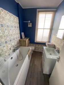 a bathroom with a tub and a sink at Apartment in Old Town near the beach in Hastings