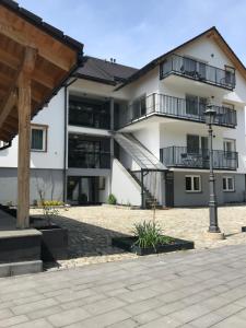 un gran edificio blanco con balcones y luz de la calle en Apartamenty Dolina Jawornika en Wisła