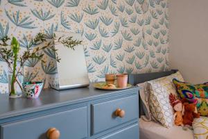 1 dormitorio con tocador azul y espejo en Bosinver Farm Cottages Buddleia en St Austell