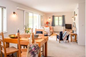 comedor y sala de estar con mesa y sillas en Bosinver Farm Cottages Buddleia en St Austell