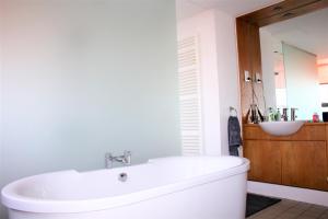 a bathroom with a white tub and a sink at Funky urban two bed flat in the heart of Bristol in Bristol