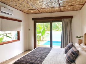 a bedroom with a bed and a view of a pool at Yumi Villas in San Vicente