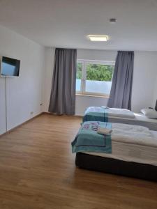 a bedroom with two beds and a flat screen tv at Twitch Appartments in Achim
