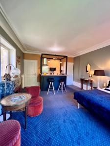 a living room with a bed and a table at Demeure de Flore - Hôtel Particulier au Cœur de Brive comprenant 8 appartements de charme in Brive-la-Gaillarde