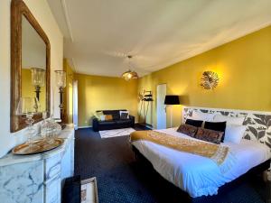 een hotelkamer met een bed en een spiegel bij Demeure de Flore - Hôtel Particulier au Coeur de Brive comprenant 7 appartements de charme in Brive-la-Gaillarde