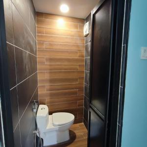 baño con aseo y pared de madera en HOMESTAY WEE INN JB en Johor Bahru