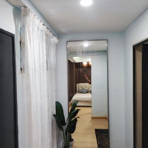 Habitación con espejo y dormitorio con cama. en HOMESTAY WEE INN JB en Johor Bahru