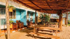 a patio with picnic tables and a building at Villa Katwe in Masaka