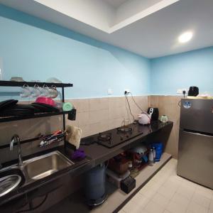 cocina con fregadero y fogones en HOMESTAY WEE INN JB en Johor Bahru