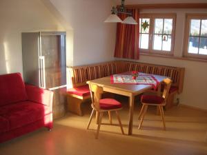 een woonkamer met een tafel en een rode bank bij Polzhof in Sankt Andrä im Lungau