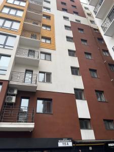 um edifício de apartamentos com varandas numa rua da cidade em — Premium apartment — em Ivano-Frankivsʼk