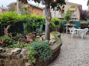 a garden with a table and chairs and a tree at Villetta orchidea in Rimini