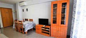 a dining room with a table and a tv and a cabinet at Apartamento Peonia 2 in Canet de Berenguer