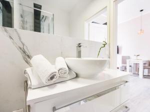 a white bathroom with a sink and towels on a counter at Charmante Suite für entspannte Tage in Bad Camberg