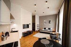 a living room with a bed and a television at Piano apartments - LICITY in Žilina