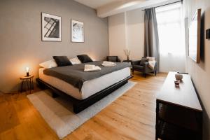 a bedroom with a bed and a living room at Piano apartments - LICITY in Žilina