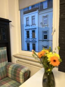 um vaso de flores sentado numa mesa com uma janela em Nostalgie Apartment - 3 Zimmer, 5 Betten, 7 Personen, kontaktloses Einchecken, Netflix em Wuppertal