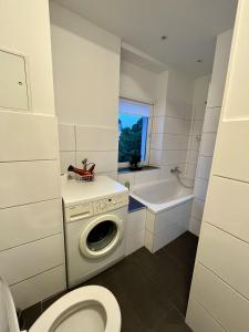 uma casa de banho com uma máquina de lavar roupa e um WC em Nostalgie Apartment - 3 Zimmer, 5 Betten, 7 Personen, kontaktloses Einchecken, Netflix em Wuppertal