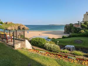 a view of a beach with a bench and the ocean at Little Rosemount in Tenby