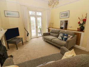 a living room with a couch and a tv at Little Rosemount in Tenby