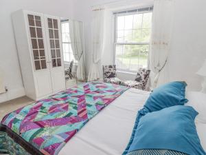 a bedroom with a bed with a quilt on it at Little Rosemount in Tenby