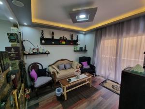 uma sala de estar com um sofá e duas cadeiras e uma mesa em Spring house em Qaryat Shākūsh