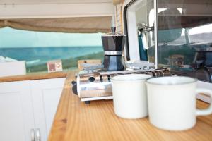 Inikcamper في إيخينيو: آلة صنع القهوة و كوبين على منضدة المطبخ